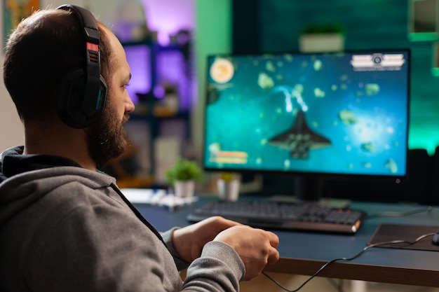 Free Photo  Person playing video games with controller on computer. player  using joystick and wearing headphones to play online game on monitor.  modern man using gaming equipment to have fun.