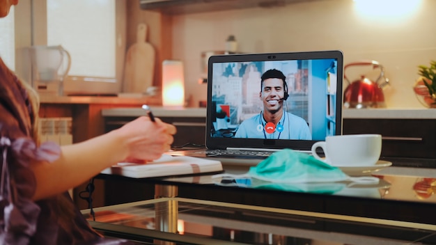 Videogesprek op computer met mixedrace-collega thuis in quarantaine