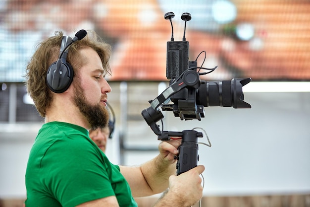 Videograaf die een film of een televisieprogramma maakt in een studio met een professionele camera backstage