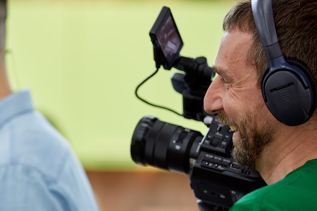 Videograaf die een film of een televisieprogramma maakt met een professionele camera, backstage.