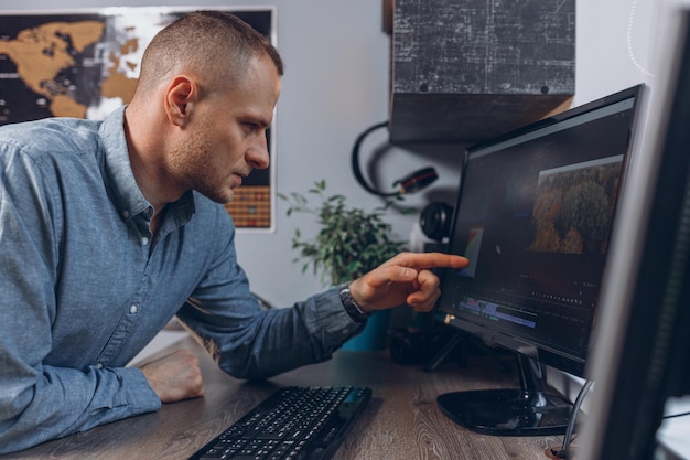 Photo videographer editing video on desktop computer and doing post production