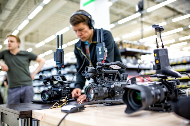 Videographer shooting a film or a television program in a\
studio with a professional camera, backstage