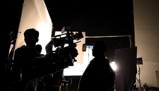 Videoproductie achter de schermen die filmploeg team in silhouet schieten of tv-film opnemen