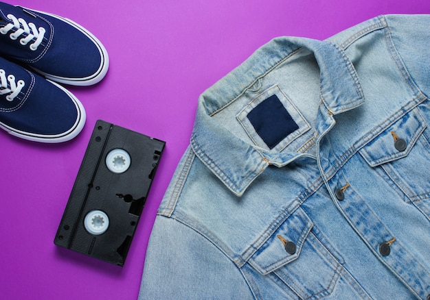 Videotape, jeans jacket, sneakers on a purple background