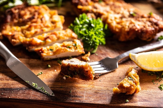 Viennese chicken steak on a fork. Traditional Austrian and German dish of chicken meat and breadcrumbs.