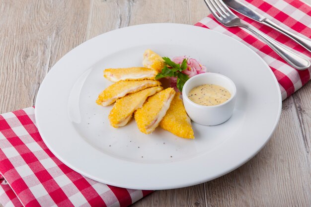 Viennese schnitzel with onions and cheese sauce