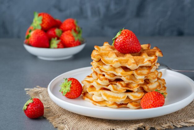 Viennese waffles with strawberries on a gray table