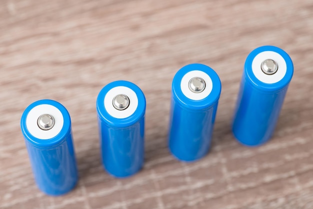 Vier blauwe generieke batterijen op houten tafel