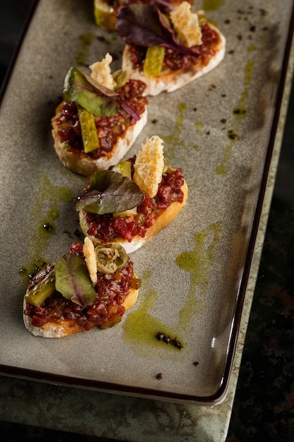 Foto vier bruschetta's met rundertartaar op een bord crostini met rundertartaar bruschettasandwich met rauw gastronomisch rundvlees