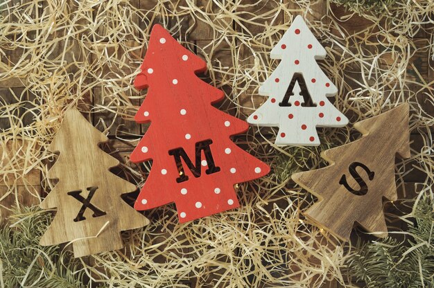 Vier decoratieve houten kerstbomen met uitgesneden letters xmas en delicatesse in de vorm van kleine botten voor huisdieren. Bovenaanzicht. Horizontaal.