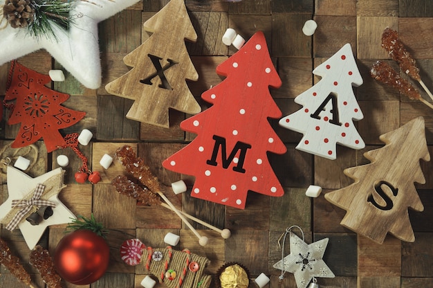 Vier decoratieve houten kerstbomen met uitgesneden letters xmas en kerstversieringen