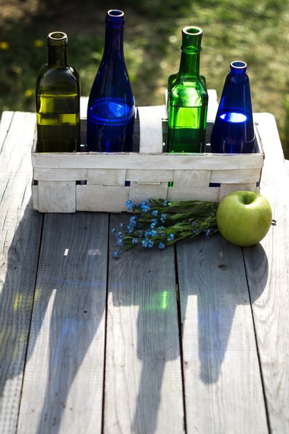 Vier flessen drankjes in een witte mand op de witte tafel