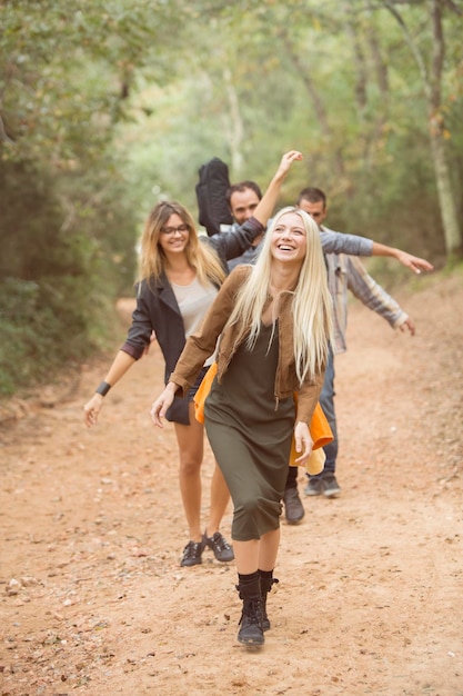 Vier gelukkige vrienden die plezier hebben op pad in het bos