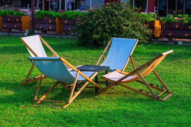 Vier houten ligstoelen op het gras