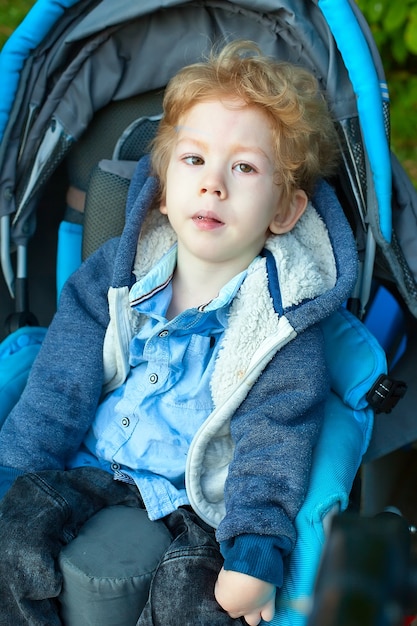 Vier-jarige jongen met hersenverlamming zit in autostoel.