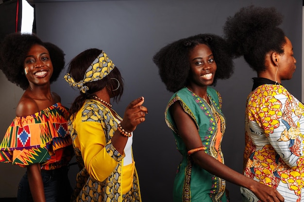 Vier jonge mooie Afrikaanse fashion modellen hebben plezier en lachen in traditionele kleding Vrouwen uit de Congo Republiek Ivoorkust en Zimbabwe