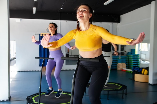 Vier jonge vrouwen op trampoline jonge fitnessmeisjes trainen op fitnessstudio