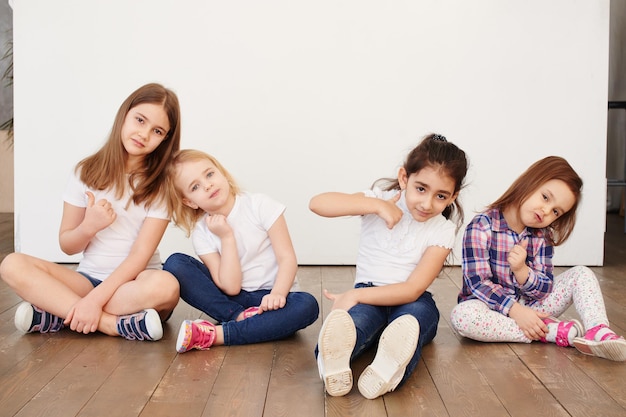 Vier kleine meisjes van een vriend zittend op een witte achtergrond gelukkige relaties