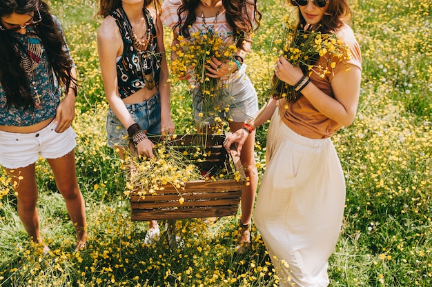 vier prachtige hippie meisje in een veld van gele bloemen