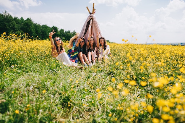 vier prachtige hippie meisje in een veld van gele bloemen