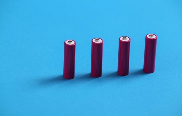 Foto vier roze aa-batterijen op blauwe achtergrond