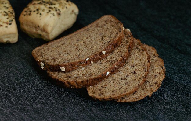 Vier sneetjes brood en twee broodjes op tafel