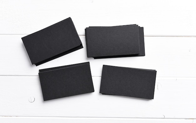 Foto vier stapels zwarte visitekaartjes op een witte houten tafel