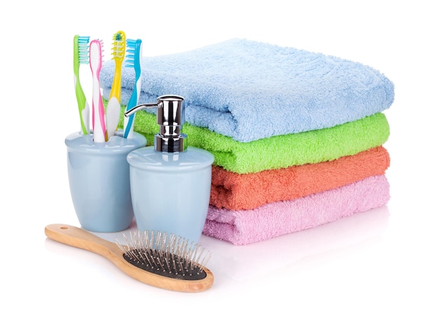 Vier tandenborstels vloeibare zeep haarborstel en kleurrijke handdoeken