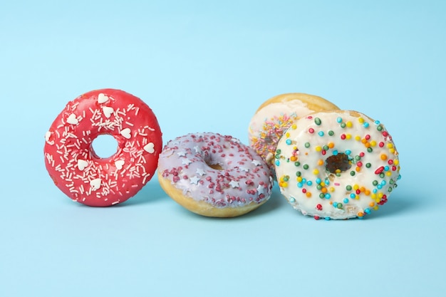 Vier verschillende smakelijke donuts op blauwe achtergrond