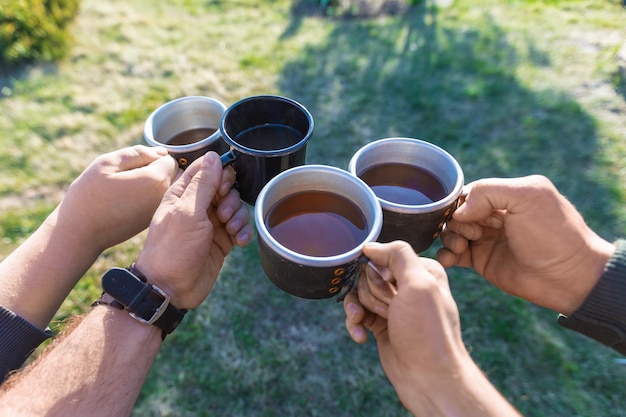 Vier vrienden drinken thee tijdens het kamperen