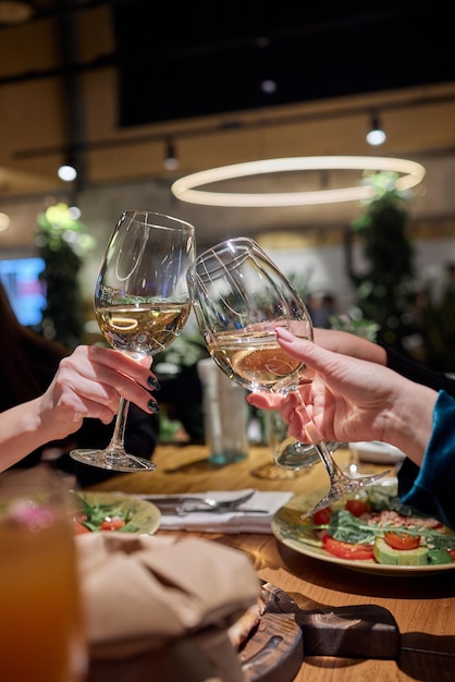 Vieren met glazen alcohol in handen gelukkige vrouwelijke vrienden die plezier hebben