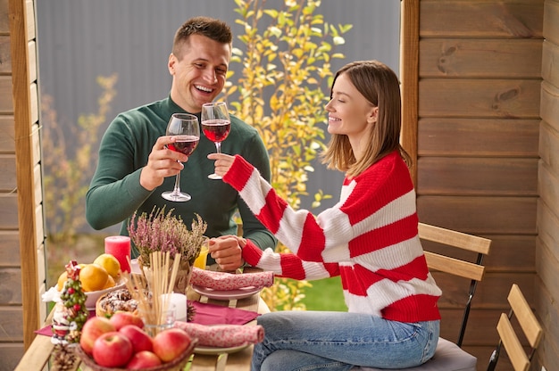 Viering. Een stel dat aan tafel zit met glazen wijn in handen