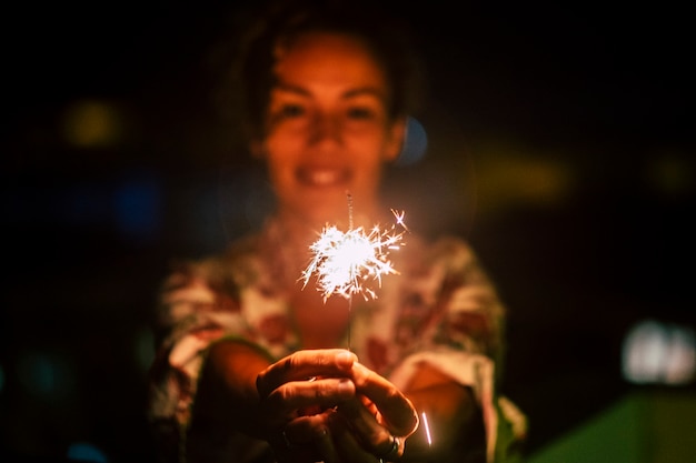 Viering en geluksconcept met vrolijke vrouw met 's nachts een sterretje fire