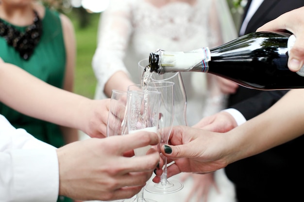 Viering Handen die de glazen champagne en wijn vasthouden en een toast uitbrengen De feestbruiloft