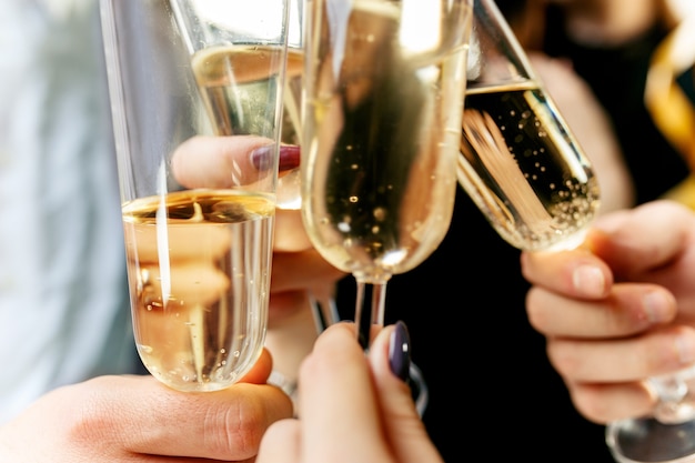 Viering Handen die de glazen champagne en wijn vasthouden en een toast uitbrengen