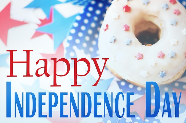 Foto viering, patriottisme, jubileum en feestdagen concept - close-up geglazuurde zoete amerikaanse donut met sterren decoratie op wegwerpbord op 4 juli feest van bovenaf met gelukkige onafhankelijkheidsdag woorden