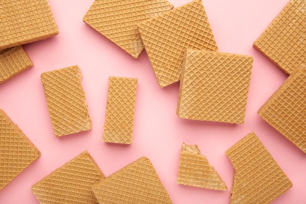 Vierkante chocolade wafeltjes op roze achtergrond. Bovenaanzicht.