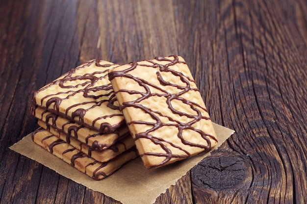 Vierkante koekjes met chocolade op donkere houten tafel