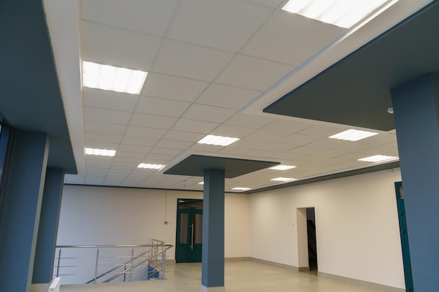 Vierkante lamp op een wit kantoorplafond Interieurontwerp op kantoor Een TL-lamp op een modern verlaagd plafond