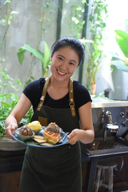 Vietnamees meisje serveert zelfgemaakt ijs met wafel in een coffeeshop