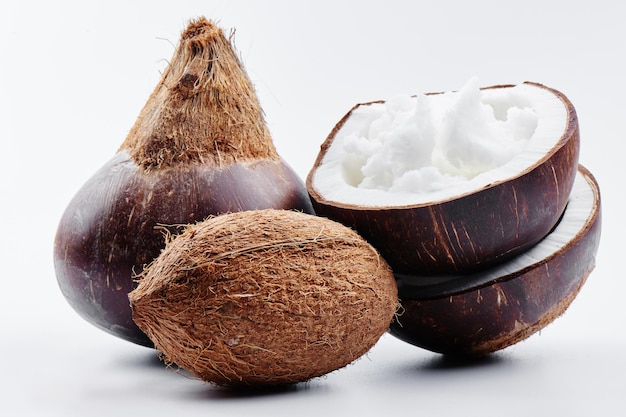 Vietnamese brown coconuts with coconut oil inside on white background