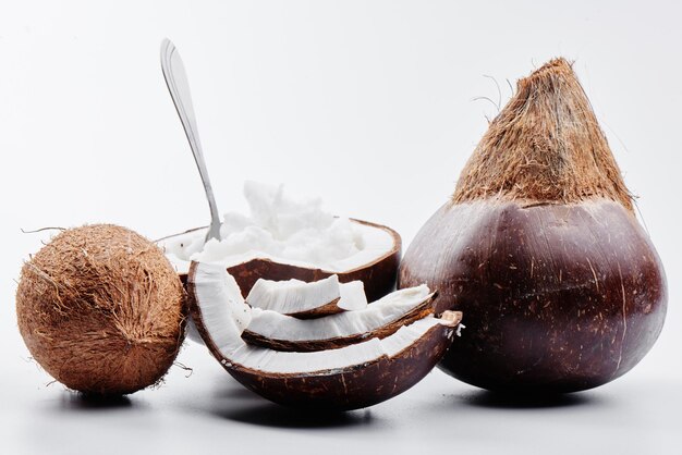 Vietnamese brown coconuts with coconut oil inside on white background