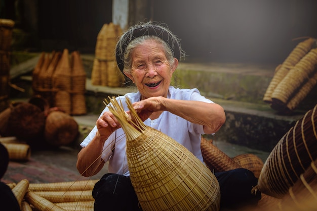 Vietnamese fishermen are doing basketry for fishing equipment at morning in Thu Sy Village