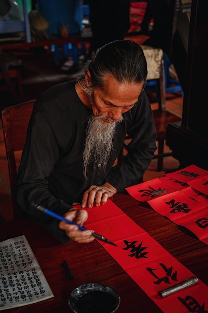 Vietnamese geleerde schrijft kalligrafie op het Long Son-kalligrafiefestival is een populaire traditie tijdens Tet-vakantie Het schrijven van coupletten voor het nieuwe jaar van het Lentefestival