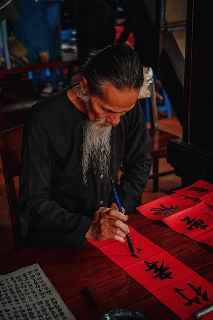 Vietnamese geleerde schrijft kalligrafie op het Long Son-kalligrafiefestival is een populaire traditie tijdens Tet-vakantie Het schrijven van coupletten voor het nieuwe jaar van het Lentefestival