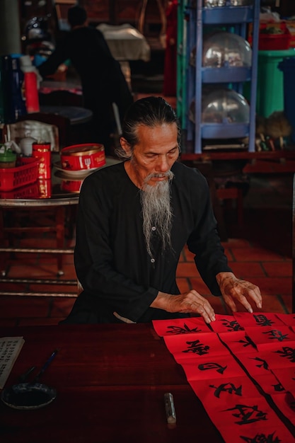 Vietnamese geleerde schrijft kalligrafie op het Long Son-kalligrafiefestival is een populaire traditie tijdens Tet-vakantie Het schrijven van coupletten voor het nieuwe jaar van het Lentefestival