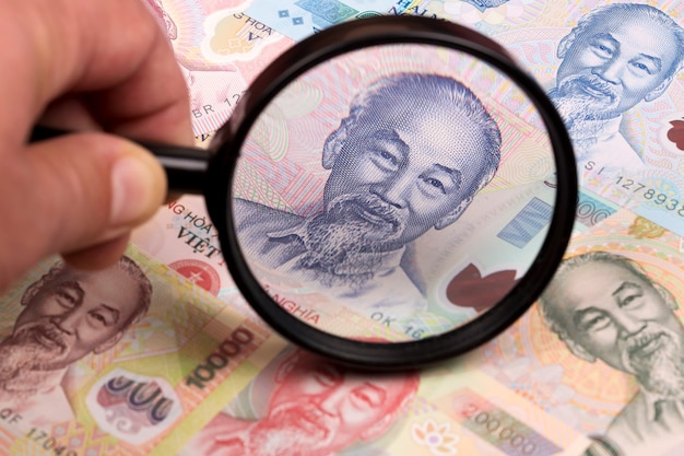 Vietnamese money in a magnifying glass a business background