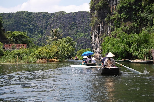 Vietnamese people and foreign traveler travel visit and amazing boat tour trip Tam Coc Bich Dong or Halong Bay on Land and Ngo Dong river and cave of limestone mountains at Ninh Binh in Hanoi Vietnam