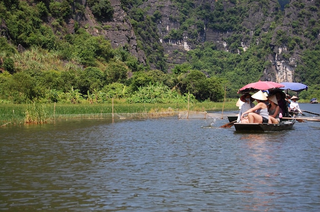 Vietnamese people and foreign travelers travel visit and boat tour trip Tam Coc Bich Dong or Halong Bay on Land and Ngo Dong river and cave of limestone at Ninh Binh on July 8 2012 in Hanoi Vietnam