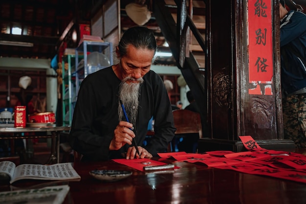 Vietnamese scholar writes calligraphy at Long Son Calligraphy festival is a popular tradition during Tet holiday Writing couplets for Spring Festival new year